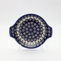 Round baking dish with handles made of Boleslawiec pottery.