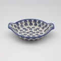 Round baking dish with handles made of Boleslawiec pottery.