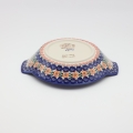 Round baking dish with handles made of Boleslawiec pottery.
