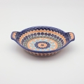 Round baking dish with handles made of Boleslawiec pottery.