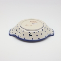 Round baking dish with handles made of Boleslawiec pottery.