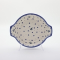 Round baking dish with handles made of Boleslawiec pottery.