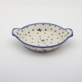 Round baking dish with handles made of Boleslawiec pottery.
