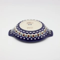 Round baking dish with handles made of Boleslawiec pottery.