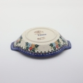 Round baking dish with handles made of Boleslawiec pottery.