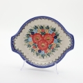 Round baking dish with handles made of Boleslawiec pottery.