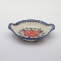 Round baking dish with handles made of Boleslawiec pottery.