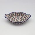 Round baking dish with handles made of Boleslawiec pottery.