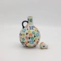 Hand-painted round decanter made from traditional Bolesławiec pottery. Unique ceramic bottle perfect for serving liqueurs, water, or as a table decoration.